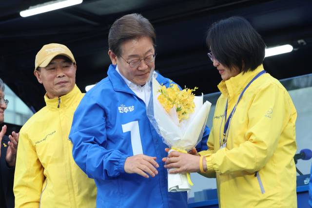 ▲더불어민주당 대선 후보 시절 이재명 대통령이 경기 안산시 단원구 안산문화광장에서 열린 유세에서 세월호 참사 유가족인 정부자씨로부터 프리지어 꽃을 받고 있다. ⓒ연합뉴스
