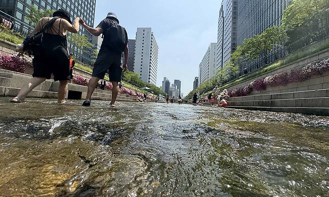 방탄소년단 콘서트를 보기 위해 한국을 찾은 호주인 부부가 청계천에 발을 담그고 물살을 느끼고 있다. 부부가 찾은 이날은 상류 일부 구간을 공개하는 ‘청계천 물 첨벙첨벙’ 행사가 진행 중이었다.