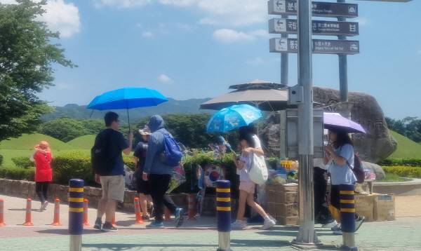 29일 낮 최고기온이 37℃를 웃도는 찜통더위가 기승을 부린 가운데 가족단위 관광객이 양산을 쓴채 경주역사유적지구를 관람하고 있다. 황기환 기자