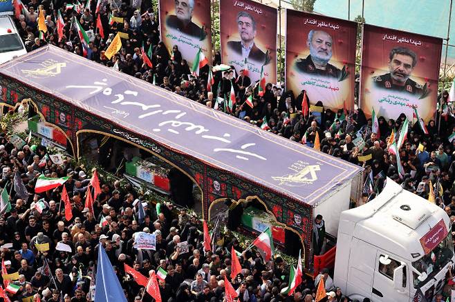 28일(현지시간) 이란 테헤란에서 이스라엘 공습으로 숨진 60명에 대한 장례식이 국장으로 거행된 가운데 이들의 관을 운구하는 트럭.(사진=AFP)