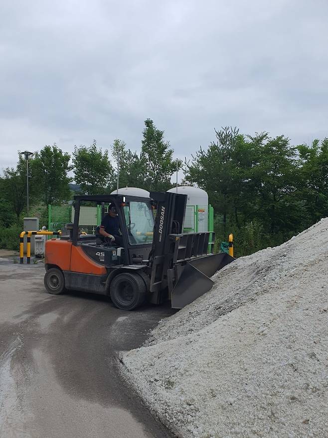 한 직원이 원료 공급을 위해 지게차를 작동하고 있다