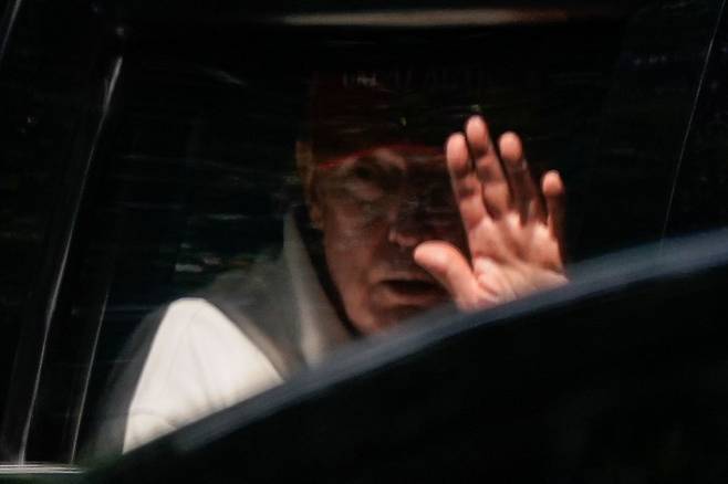 도널드 트럼프 미국 대통령이 28일(현지시간) 버지니아주 스털링에 있는 트럼프 내셔널 골프클럽을 떠나며 차안에서 손을 흔들고 있다. 연합뉴스