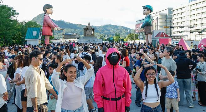 29일 서울 종로구 광화문광장에서 '2025 K콘텐츠 서울여행주간: 소울스팟을 찾아라' 행사의 일환으로 마련된 넷플릭스 오징어 게임 체험존에서 외국인 관광객들이 기념촬영을 하고 있다.