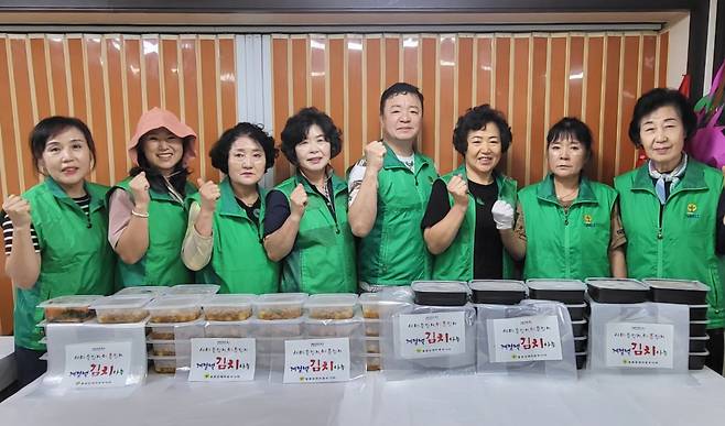 이정호 울릉군새마을회장, 김인숙 울릉읍 부녀회장 및 회원들이 김치를 만들고 파이팅을 외치고 있다. /새마을부녀회 제공