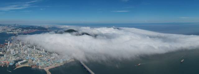 부산 지역에 폭염 특보가 발효된 30일 오후 부산 영도구 봉래산 일대에 짙은 해무가 밀려들어 장관을 연출하고 있다. 해무는 따뜻한 공기가 찬 해면으로 이동할 때 해면 부근의 공기가 냉각돼 생기는 안개로 우리나라에서는 7월에 가장 많이 발생한다. 정종회 기자 jjh@