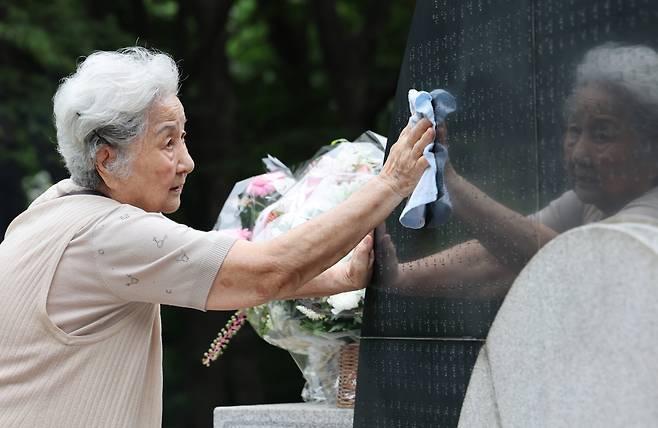 29일 서울 서초구 매헌시민의숲에서 삼풍백화점 붕괴 사고 30주기 추모식이 열렸다. 유가족이 희생자들의 이름이 적힌 위령탑을 손수건으로 닦고 있다./장경식 기자