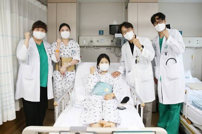 다낭성 신증후군 환자 이가영 씨(가운데)가 로봇 신장 이식 후 20일 의료진과 기념 사진을 찍고 있다. 왼쪽에서 두 번째는 신장 공여자인 이 씨의 언니, 네 번째는 신성 서울아산병원 신·췌장이식외과 교수. 서울아산병원 제공.