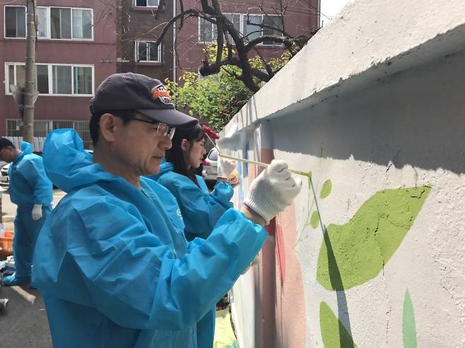 한미글로벌 구성원들이 장애인 복지시설 담벼락에 벽화 그리기 봉사활동을 하고 있다. 한미글로벌 제공