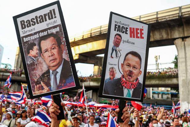28일 태국 방콕에서 패통탄 친나왓 총리의 사퇴를 촉구하는 대규모 반정부 시위가 벌어진 가운데, 한 시위 참가자가 훈센(왼쪽) 캄보디아 전 총리의 얼굴이 그려진 손팻말을 들고 항의하고 있다. 방콕=로이터 연합뉴스