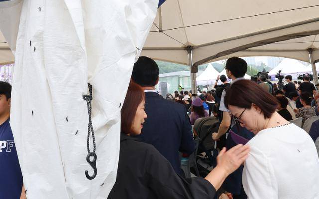 27일 인천 서구 신검단중앙역에서 열린 인천도시철도 1호선 검단연장선 개통 기념식장에서 한 시민이 몸에 붙은 러브버그를 떼어내고 있다. 연합뉴스