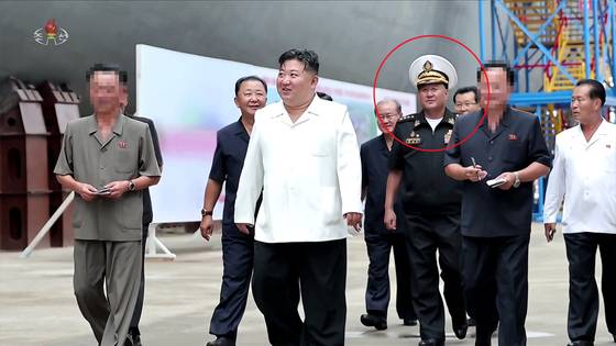 북한 조선중앙TV가 29일 방영한 기록영화 '위민헌신의 여정, 새로운 변혁의 2024년'에 김명식 전 해군사령관(빨간색 동그라미)의 모습이 삭제되지 않은 채 등장했다. 조선중앙TV 화면