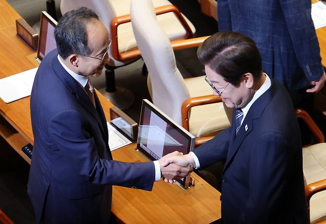 이재명 대통령이 26일 국회 본회의장에서 추가경정예산 시정연설을 마친 뒤 국민의힘 추경호 의원과 악수하고 있다.  /  사진=뉴스1