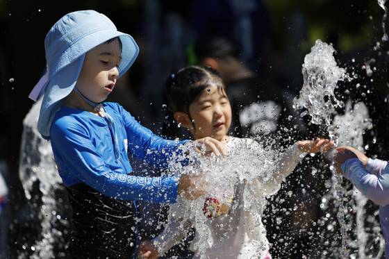 Children cool off in a water fountain in Damyang, South Jeolla, on the afternoon of June 29. [NEWS1]
