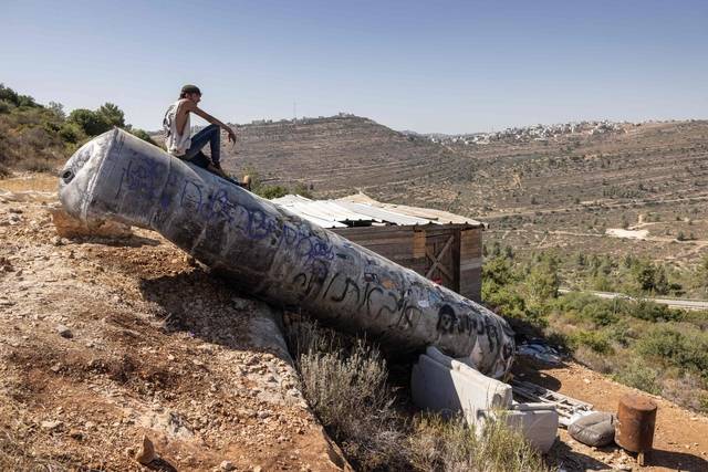 미사일 잔해 위 팔레스타인 청년  : 29일 한 팔레스타인 남성이 요르단 강 서안지구 내에 위치한 네리아 정착촌 인근에 떨어진 이란 미사일 잔해 위에 앉아 있다. 이날 도널드 트럼프 미국 대통령은 이스라엘과 이란 간 휴전으로 ‘아브라함 협정’을 확대할 수 있는 기회가 생겼다고 밝혔다.    AFP 연합뉴스