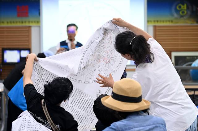 지난 5월 31일 ‘별 헤는 밤 가족 캠프’ 참여 가족들이 별자리에 대해 살펴보고 있다.   윤성호 기자