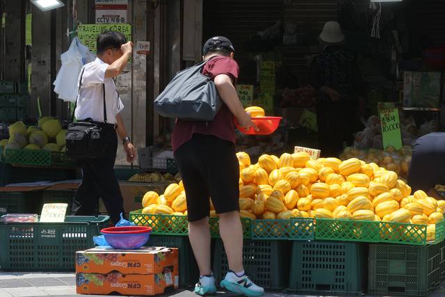 지난 22일 서울 남대문시장에서 시민들과 관광객들이 상점을 둘러보고 있다. 정부가 2차 추가경정예산안으로 전 국민에게 15∼50만원씩 민생회복 소비쿠폰을 지급하기로 하면서 실제 소비 진작 효과에 이목이 쏠린다. 연합뉴스