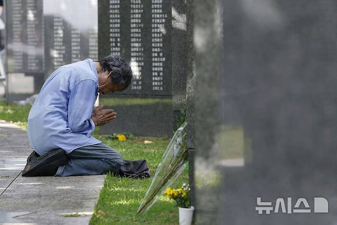 [이토만=AP/뉴시스] 23일 오키나와 전투 종전 80주년을 맞아 일본 오키나와현 이토만 평화기념공원 내 '평화의 초석' 앞에서 한 유족이 기도하고 있다. 2025.06.23.