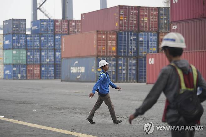인도네시아 항구 인도네시아 자카르타 국제 컨테이너 터미널(JICT)에 쌓여있는 컨테이너 옆으로 근로자들이 지나가고 있다.
[AP 연합뉴스 자료사진. 재판매 및 DB 금지]