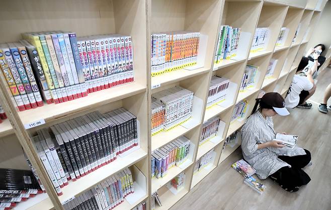 지난 29일 오전 부산 연제구 연제만화도서관을 찾은 시민들이 책장에 기대어 만화책을 읽고 있다./김동환 기자