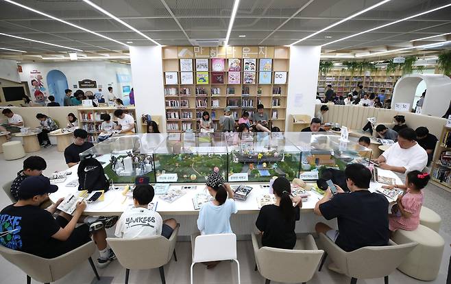 지난 29일 오전 부산 연제구 연제만화도서관을 찾은 시민들이 피규어가 전시된 책상에서 만화책을 읽고 있다./김동환 기자