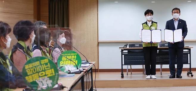 나순자 전국보건의료산업노동조합 위원장(왼쪽)과 권덕철 보건복지부 장관이 2021년 9월2일 새벽 서울 영등포구 의료기관평가인증원에서 노정 실무교섭이 타결된 뒤 서명한 합의문을 교환하고 기념촬영을 하고 있다. 연합뉴스