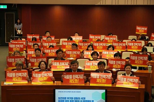 지난달 30일 국회에서 열린 보건의료노조 주최 이재명 정부 공약 및 정책협약 이행 과제 토론회에 앞서 참석자들이 팻말을 들고 기념촬영을 하고 있다. 보건의료노조 제공