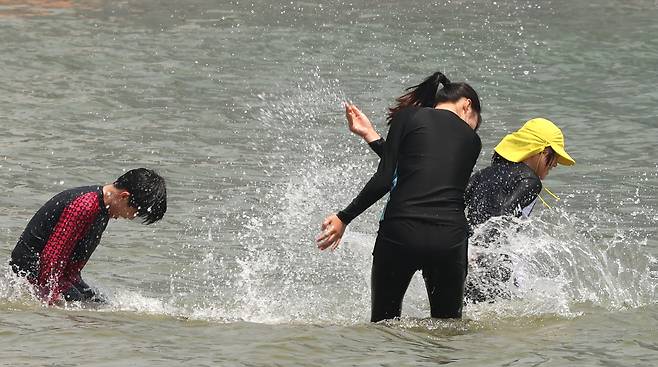 부산지역에 올해 첫 폭염특보가 발효된 지난달 27일 오후 부산 수영구 광안리해수욕장에서 시민과 관광객들이 물놀이를 즐기고 있다. 연합뉴스