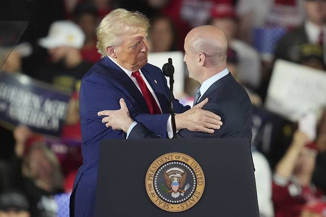 도널드 트럼프 미국 대통령이 지난 4월29일(현지시간) 미시간주 워런에서 취임 100일을 맞아 연설하며 스티븐 밀러 백악관 부비서실장과 인사하고 있다. AP연합뉴스