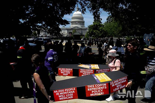 [AP/뉴시스] 트럼프의 감세 및 지출 법안에 대한 상원 투표 절차가 진행중인 미 연방의사당과 그 앞 시위대 모습