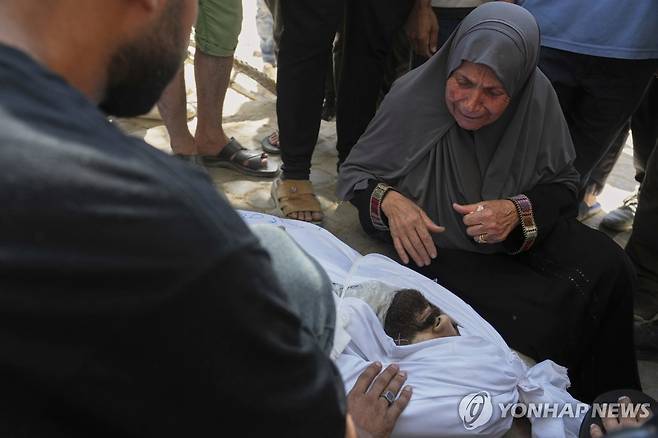Israel Palestinians (AP=연합뉴스) 이스라엘군의 가자시티 카페 공습으로 사망한 팔레스타인 저널리스트 이스마일 아부 하타브의 모친이 아들의 시신 옆에서 흐느끼는 모습. 2025.6.30