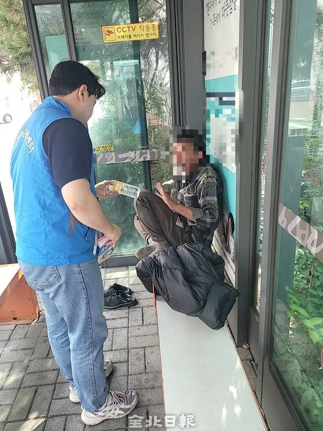 다시서기지원센터 관계자가 노숙인에게 물과 위생용품을 전달하고 있다. /다시서기지원센터