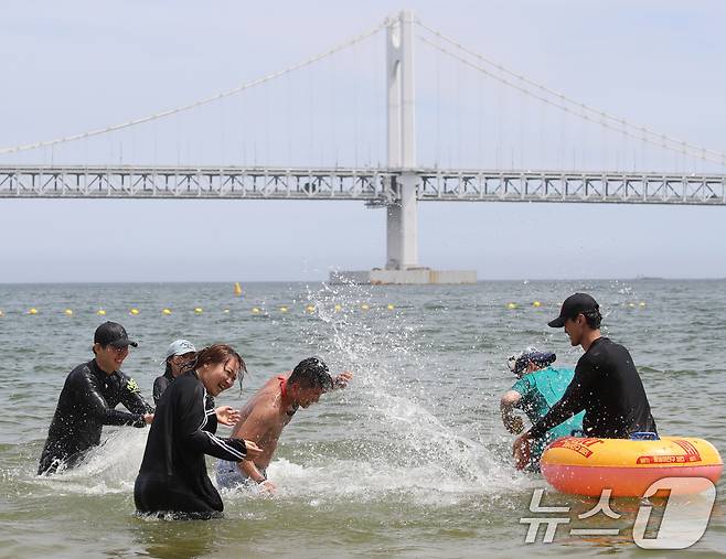 무더위가 기승을 부린 1일 개장한 부산 수영구 광안리해수욕장을 찾은 관광객들이 물놀이를 즐기며 더위를 식히고 있다. 2025.7.1/뉴스1 ⓒ News1 윤일지 기자