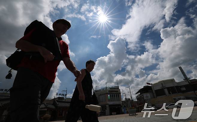 소나기가 그치고 무더위가 찾아온 1일 오후 경기 수원시 팔달구 수원화성 화홍문 인근에서 관광객들이 뜨거운 햇살 아래를 걸어가고 있다. 2025.7.1/뉴스1 ⓒ News1 김영운 기자