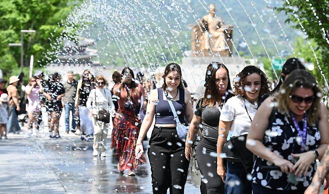 지난 5월 22일 오후, 외국인 관광객들이 줄을 지어 서울 종로구 광화문광장 터널분수를 지나며 더위를 식히고 있다. / 고운호 기자