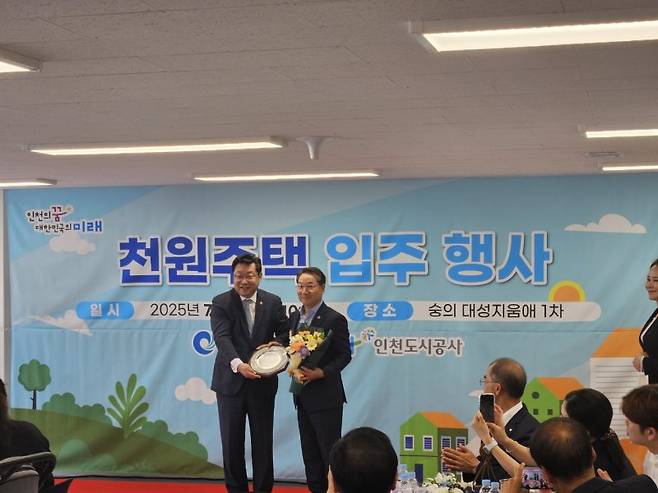 주형환 저출산고령사회위원회 부위원장(왼쪽)이 2일 인천 미추홀구에서 열린 '천원주택' 입주행사에서 유정복 인천시장에게 감사패를 전달하고 기념촬영을 하고 있다. 저고위 제공
