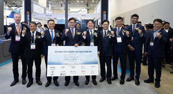 정연인 두산에너빌리티 부회장(왼쪽 세번째부터)과 우원식 국회의장, 김형근 한국풍력산업협회 회장, 양병내 산업통상자원부 상임위원이 2일 부산 벡스코에서 개막한 '2025 해상풍력 공급망 컨퍼런스 전시회'에서 9개 협력사 대표와 '공급망 활성화 상생협약'을 체결한 뒤 기념촬영을 하고 있다. 두산에너빌리티 제공
