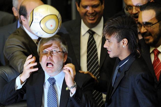 마르코 마이아 브라질 하원의장(왼쪽)이 지난 2012년 4월 10일(현지시간) 브라질 브라질리아에서 열린 클럽 창단 100주년 기념 특별의회에서 네이마르(오른쪽)가 지켜보는 가운데 슛을 하고 있다. 지난 1일 브라질 대법원은 2023년 극우 성향의 자이르 보우소나루 전 대통령 지지자들이 브라질 집권당을 습격하는 과정에서 네이마르의 사인이 담긴 축구공을 훔친 혐의로 한 남성에게 징역 17년형을 선고했다. AFP=연합뉴스