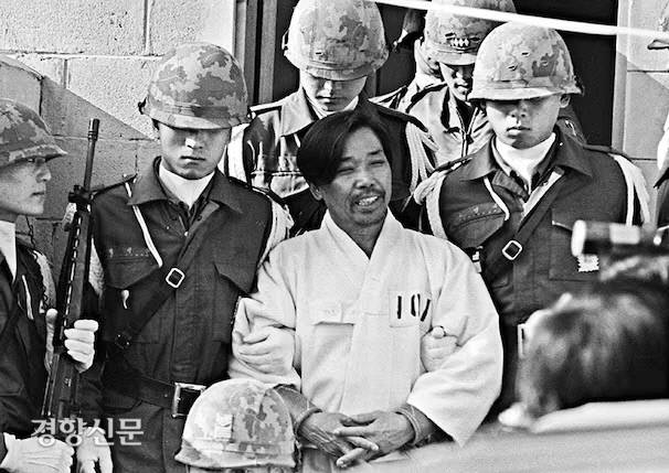 1979년 10월26일 밤 박정희 당시 대통령에게 총을 쏴 살해한 김재규 전 중앙정보부장이 그해 12월20일 육군본부 계엄 보통군법회의(재판장 김영선 중장)에서 선고를 받기 위해 포승에 묶인 채 걸어오며 웃고 있다. 경향신문 자료사진