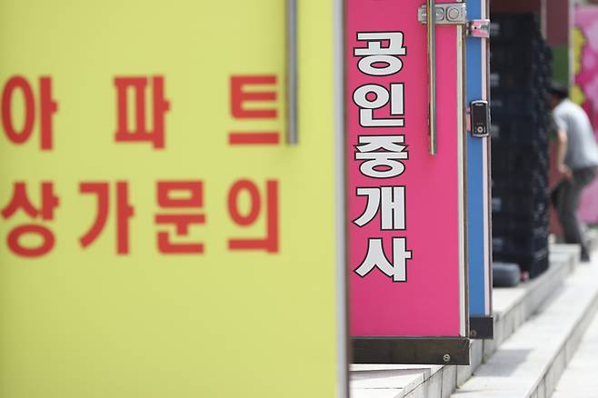 30일 서울의 한 부동산 중개업소 앞에 시민이 오가고 있다. [사진 출처 = 연합뉴스]