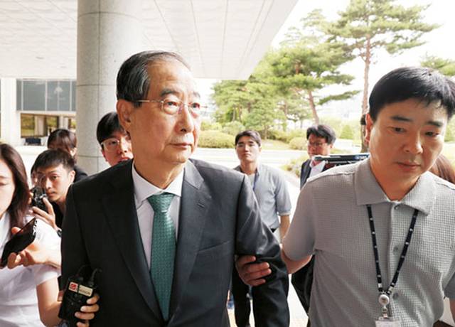 착잡한 韓 전총리  : 한덕수(가운데) 전 국무총리가 2일 오전 내란특검팀 수사관의 손에 이끌려 특검 사무실이 있는 서울 서초구 서울고검 청사로 들어서고 있다. 뉴시스