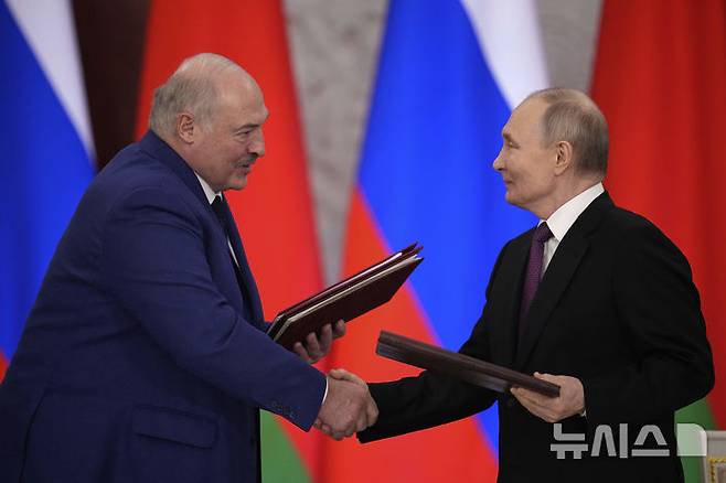 [모스크바=AP/뉴시스] 블라디미르 푸틴(오른쪽) 러시아 대통령과 알렉산드르 루카셴코 벨라루스 대통령이 3월 13일  러시아 모스크바 크렘린궁에서 협정서 서명 후 악수하고 있다. 푸틴 대통령은 회담 후 기자회견에서 "우크라이나와 30일 일시 휴전은 우크라이나가 전열을 재정비할 시간만 벌어줄 것"이라고 주장했다. 2025.03.14.