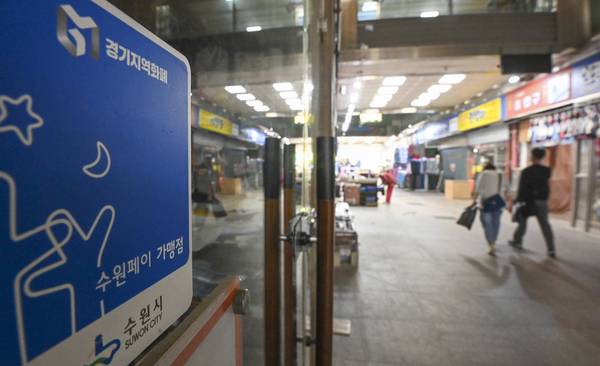 수원시내 한 전통시장에 경기지역화폐 가맹점 홍보물이 부착돼있다. /경인일보DB