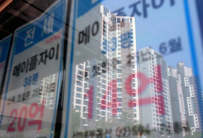 최근 급격한 서울 집값 상승으로 서울 평균 전세가율(매매가격 대비 전세가격비율)은 8년여 만에 최저치를 기록한 가운데 6월 23일 서울 시내의 한 부동산에 붙은 전세 매물 안내문에 인근 아파트 모습이 비치고 있다. [사진 출처 = 연합뉴스]
