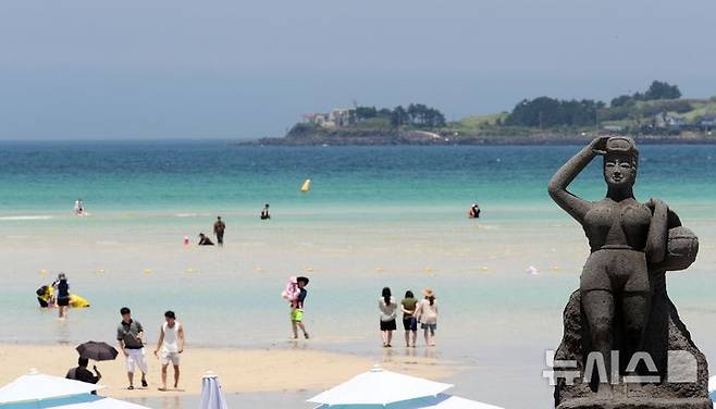 [제주=뉴시스] 우장호 기자 = 무더위가 기승을 부린 3일 오후 제주시 한림읍 금능해수욕장을 찾은 피서객들이 바닷물에 발을 담그며 더위를 식히고 있다. 기상청은 이날 제주 지역 장마가 사실상 지난달 26일 종료됐다고 발표했다. 올해 제주 장마 기간은 지난달 12~26일로 2주간이었으며, 이는 기상 관측 사상 가장 일찍 종료된 장마로 기록됐다. 2025.07.03. woo1223@newsis.com