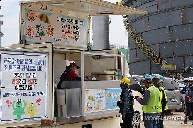 커피차 이용하는 플랜트 건설 근로자들 (울산=연합뉴스) 장지현 기자 = 폭염특보 일주일째인 3일 울산 울주군 온산읍 에쓰오일 샤힌프로젝트 건설 현장에서 근로자들이 커피차를 이용하며 더위를 달래고 있다. 이날 울산 전역에는 폭염경보와 폭염 영향예보 '경고' 단계가 발령됐다. 2025.7.3 jjang23@yna.co.kr