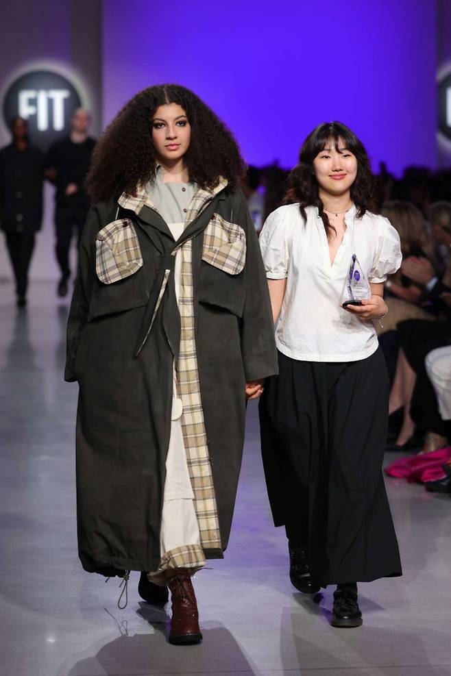 2024년 FIT 패션쇼에서 자신이 디자인한 옷을 입은 모델과 걷고 있는 김남우(오른쪽) 디자이너. 사진=본인제공