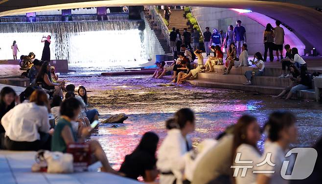 서울에 올해 처음으로 열대야가 기록된 30일 서울 청계천에서 시민들과 외국인 관광객들이 더위를 식히고 있다. 열대야는 밤 사이(전날 오후 6시 1분부터 다음날 오전 9시까지) 기온이 25도 이상으로 유지되는 현상이다. 2025.6.30/뉴스1 ⓒ News1 박지혜 기자