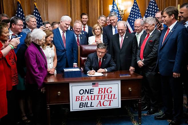 마이크 존슨(가운데) 미하원의장이 3일(현지 시각) 미국 워싱턴DC 미 의사당에서 감세법안 통과 후 공화당 의원들과 가진 법안 등록식에서 예산안에 서명을 하고 있다./EPA 연합뉴스