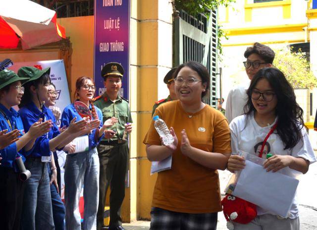 지난달 26일 베트남 하노이 판딘풍 고교 앞에서 자원봉사자들이 전국 고등학교 졸업 시험 첫날 두 과목을 마치고 나온 수험생에게 박수를 보내고 있다. 하노이=허경주 특파원