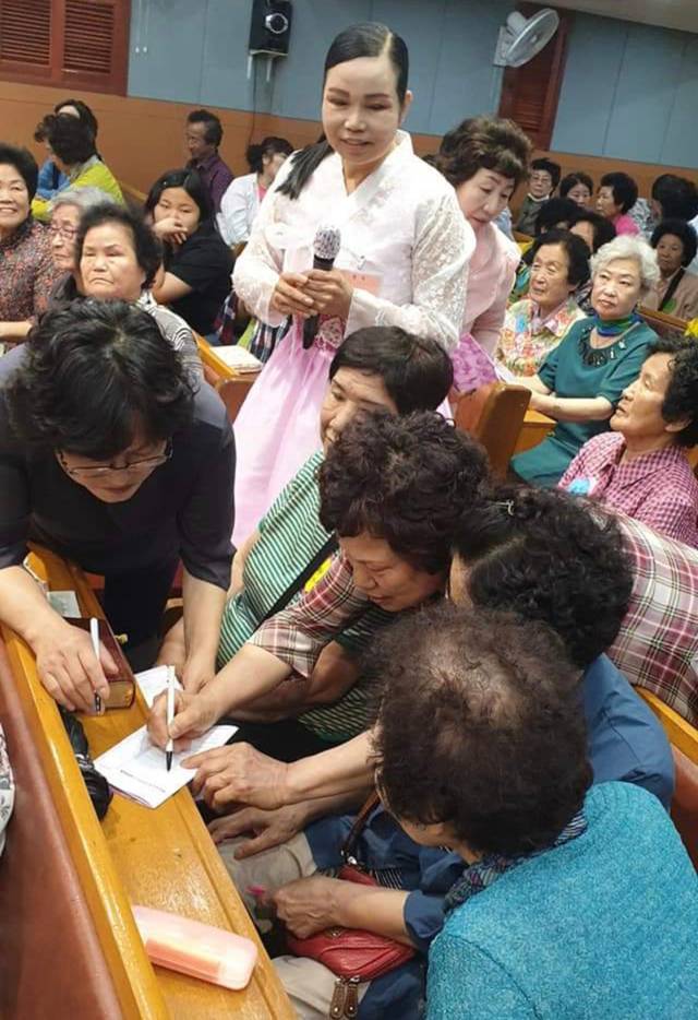 예배에 참석한 지역 주민들이 집회 마지막 시간에 예수님을 믿겠다고 결신카드를 작성하는 모습. 구 집사 제공